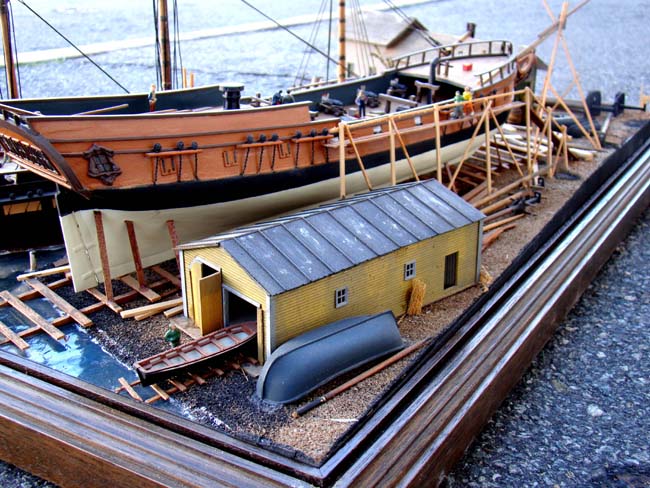 A fabulous and highly detailed scale model diorama circa 1920 of a New England Ship yard circa 1800-1812 making repairs on a 38 Gun American Frigate and a 10 Gun Privateer built circa 1785. — image 11